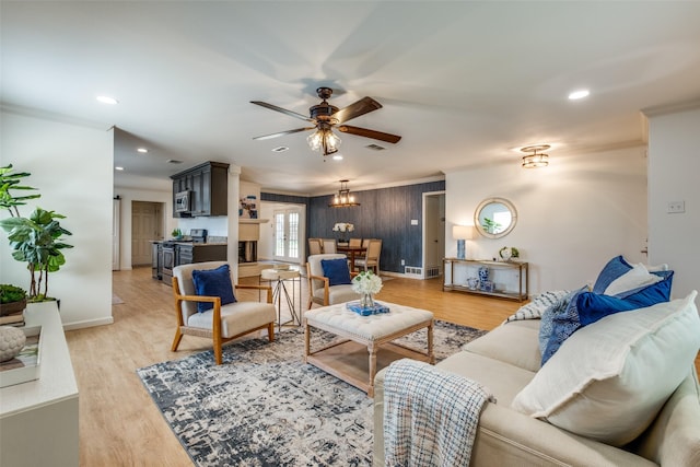 living room with a ceiling fan, baseboards, light wood-style floors, ornamental molding, and recessed lighting