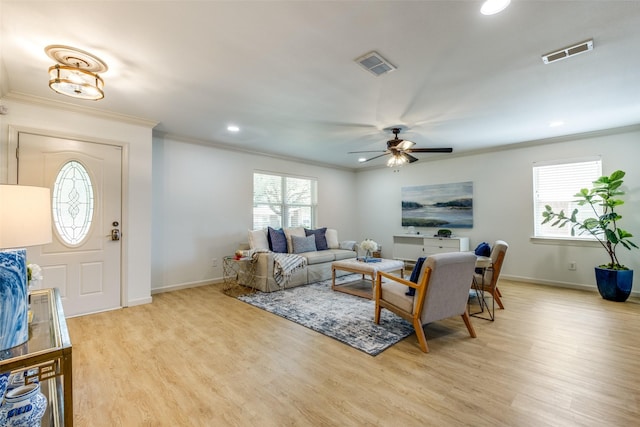 living room featuring crown molding, light wood-type flooring, a ceiling fan, baseboards, and recessed lighting