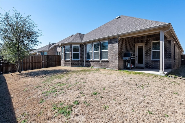 2507 Linwood Dr, Mansfield, TX 76084 - back of property featuring brick siding, fence, a patio area, and a shingled roof