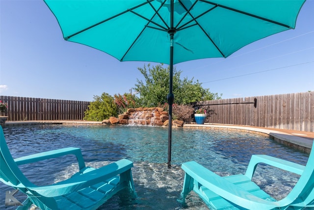 view of pool with a fenced backyard