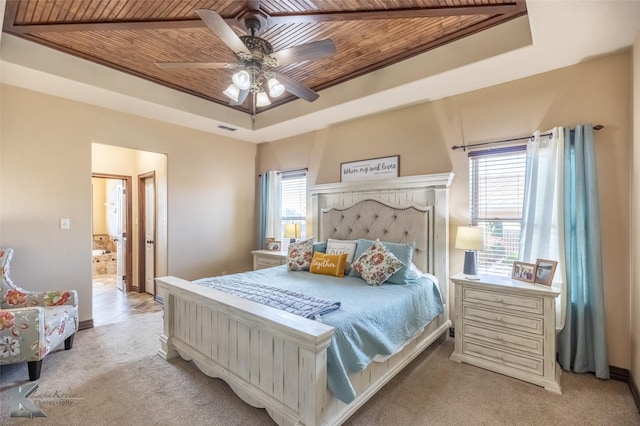 bedroom with wood ceiling, a tray ceiling, light carpet, baseboards, and a ceiling fan
