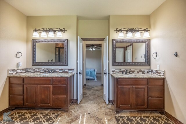 bathroom featuring decorative backsplash, two vanities, and baseboards