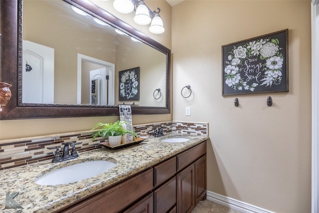 full bathroom featuring double vanity, backsplash, tile patterned flooring, and baseboards