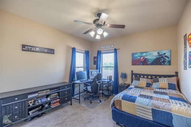 bedroom featuring carpet, a ceiling fan, and a desk