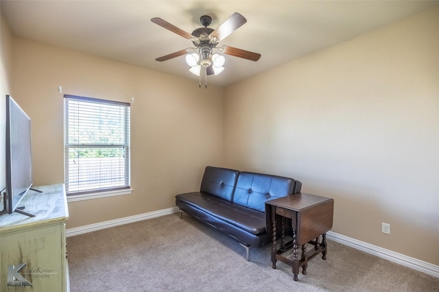 living area with carpet floors, baseboards, and ceiling fan