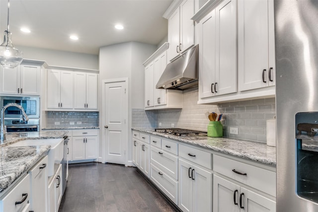 kitchen with under cabinet range hood, appliances with stainless steel finishes, white cabinetry, and recessed lighting