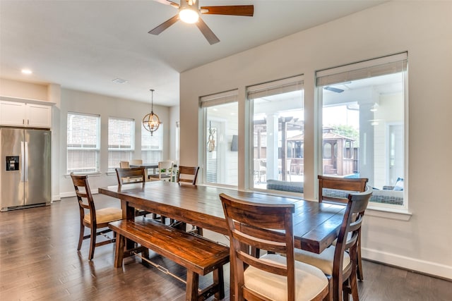 dining space featuring a ceiling fan, baseboards, dark wood finished floors, and a chandelier