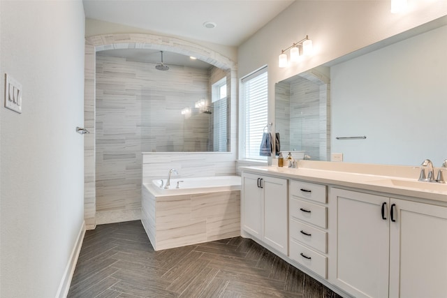 full bathroom featuring tiled shower, a bath, and double vanity