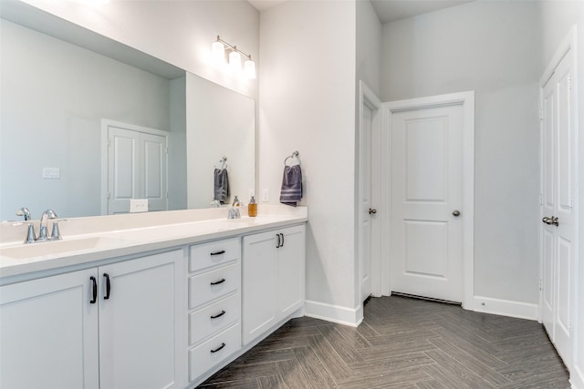 bathroom featuring baseboards and double vanity