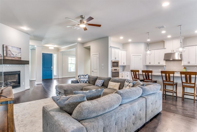 living area with ceiling fan, dark wood-style flooring, recessed lighting, a fireplace, and baseboards