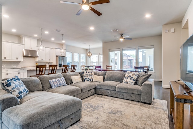 living area with a ceiling fan, dark wood-type flooring, recessed lighting, and baseboards