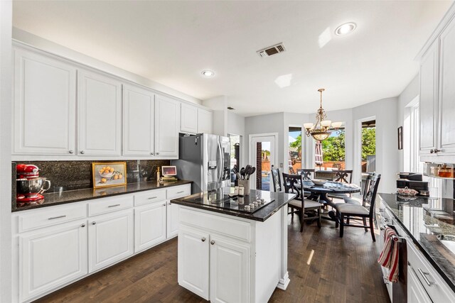 2631 Valley Creek Trl, Mckinney, TX 75072 - kitchen with stainless steel fridge, a chandelier, backsplash, white cabinets, and recessed lighting