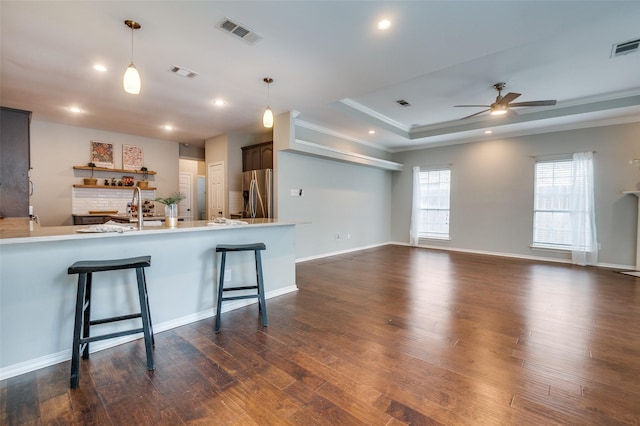 6308 Bittersweet Dr, Arlington, TX 76001 - kitchen with stainless steel fridge, ceiling fan, dark wood-style flooring, a raised ceiling, and a kitchen bar