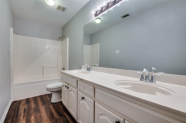 6308 Bittersweet Dr, Arlington, TX 76001 - bathroom featuring toilet, double vanity, wood finished floors, and washtub / shower combination