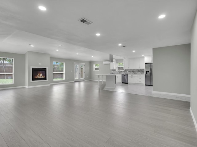 2834 Sunny Hill Ln, Farmers Branch, TX 75234 - unfurnished living room with baseboards, recessed lighting, light wood finished floors, and a glass covered fireplace