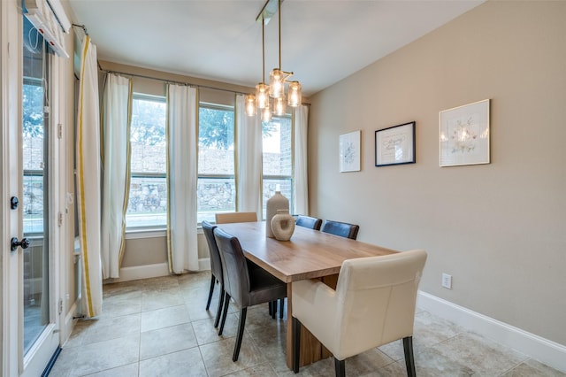 dining room featuring baseboards, a chandelier, and light tile patterned floors