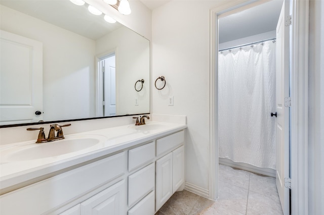 bathroom featuring double vanity, tile patterned flooring, and baseboards