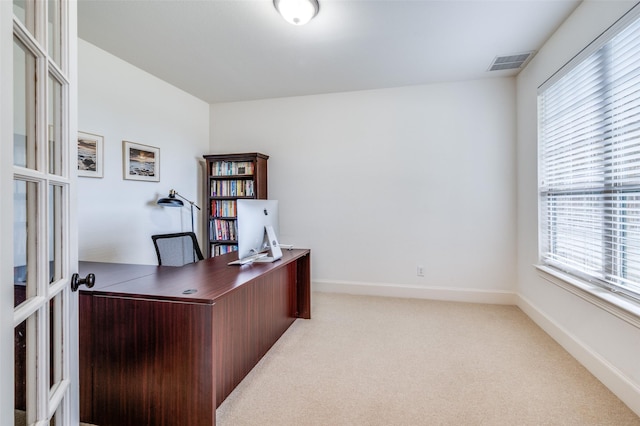 home office with carpet, healthy amount of natural light, french doors, and baseboards