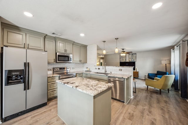 605 Preston Dr, Royse City, TX 75189 - kitchen with stainless steel appliances, a sink, a peninsula, gray cabinets, and light wood-type flooring
