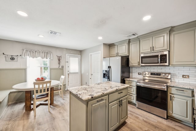 605 Preston Dr, Royse City, TX 75189 - kitchen with appliances with stainless steel finishes, gray cabinetry, tasteful backsplash, a center island, and light wood-type flooring
