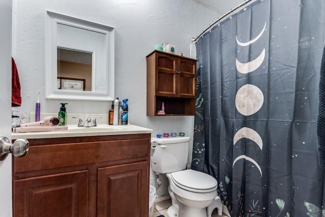 2818 Ashglen Dr, Garland, TX 75043 - full bath with toilet, vanity, a textured wall, and a shower with curtain