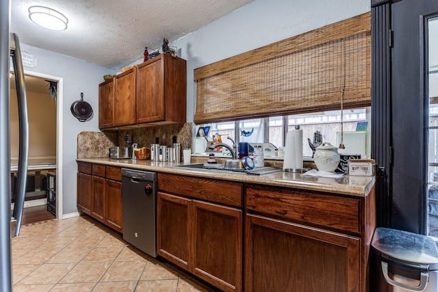 2818 Ashglen Dr, Garland, TX 75043 - kitchen featuring dishwasher, a sink, light tile patterned floors, light countertops, and a textured ceiling