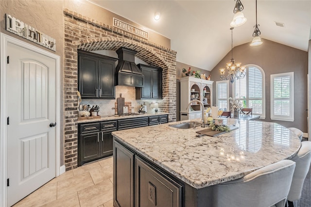 1212 Teton Dr, Burleson, TX 76028 - kitchen with a sink, a chandelier, premium range hood, stainless steel gas stovetop, and light stone counters