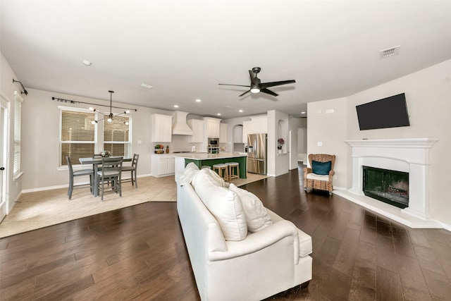 8625 Tribute Ln, Fort Worth, TX 76131 - living room featuring dark wood-style floors, ceiling fan, a glass covered fireplace, baseboards, and recessed lighting
