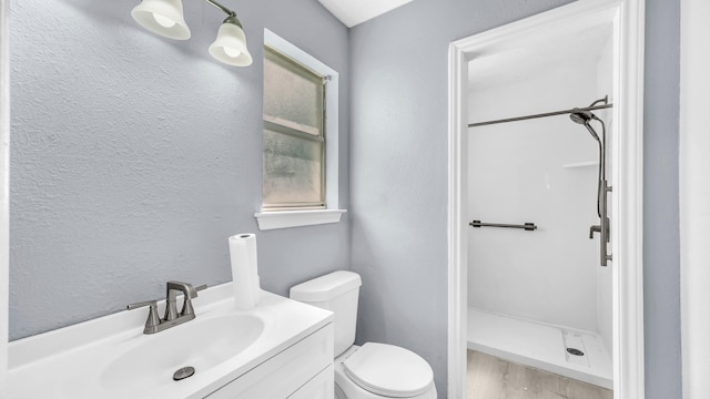 2017 Moline Dr, Haltom City, TX 76117 - full bath with toilet, a shower stall, a textured wall, vanity, and wood finished floors