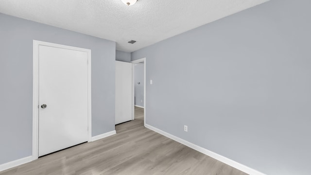 2017 Moline Dr, Haltom City, TX 76117 - unfurnished bedroom with wood finished floors, baseboards, and a textured ceiling