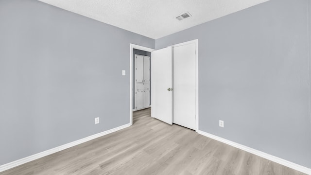 2017 Moline Dr, Haltom City, TX 76117 - unfurnished bedroom with wood finished floors, baseboards, and a textured ceiling