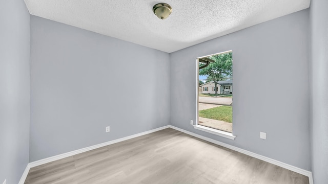 2017 Moline Dr, Haltom City, TX 76117 - empty room with a textured ceiling, wood finished floors, and baseboards