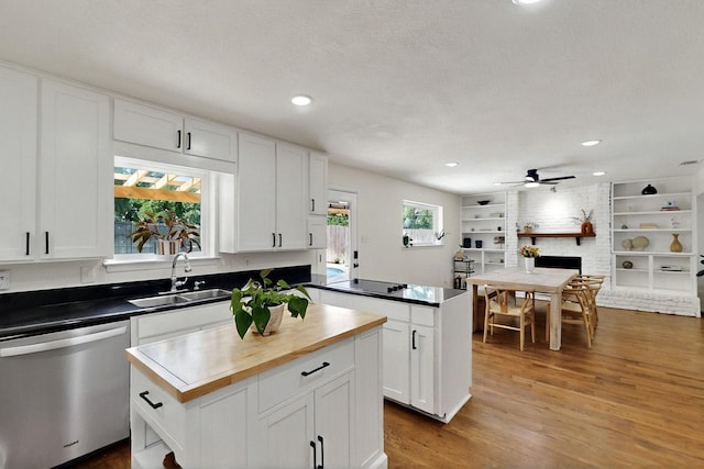 53 Devonshire Dr, Bedford, TX 76021 - kitchen with stainless steel dishwasher, a sink, wood finished floors, a ceiling fan, and white cabinets