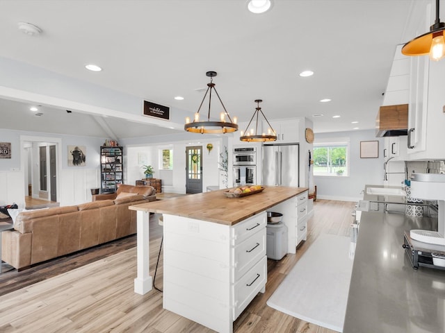 325 Beasley Rd, Combine, TX 75159 - kitchen featuring wooden counters, stainless steel appliances, white cabinetry, light wood-style floors, and a chandelier