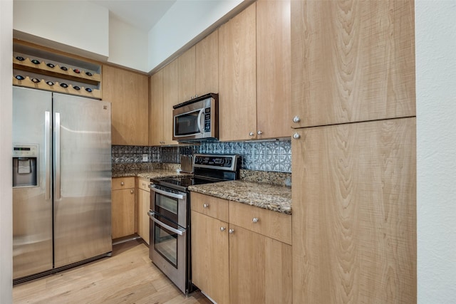 3225 Turtle Creek Blvd Unit 326, Dallas, TX 75219 - kitchen with appliances with stainless steel finishes, backsplash, light wood-type flooring, dark stone counters, and light brown cabinets