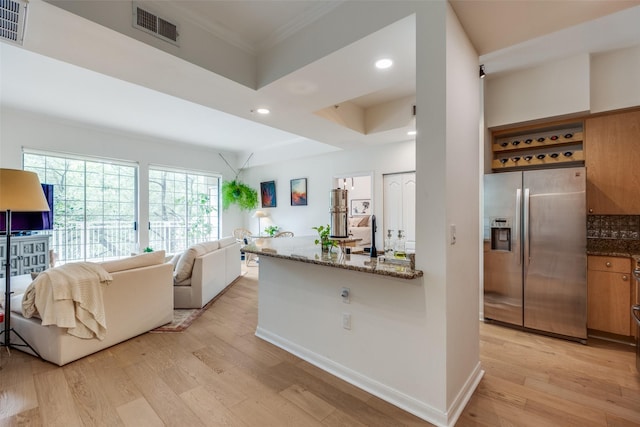 3225 Turtle Creek Blvd Unit 326, Dallas, TX 75219 - kitchen with stainless steel refrigerator with ice dispenser, light wood-type flooring, dark stone counters, open floor plan, and crown molding