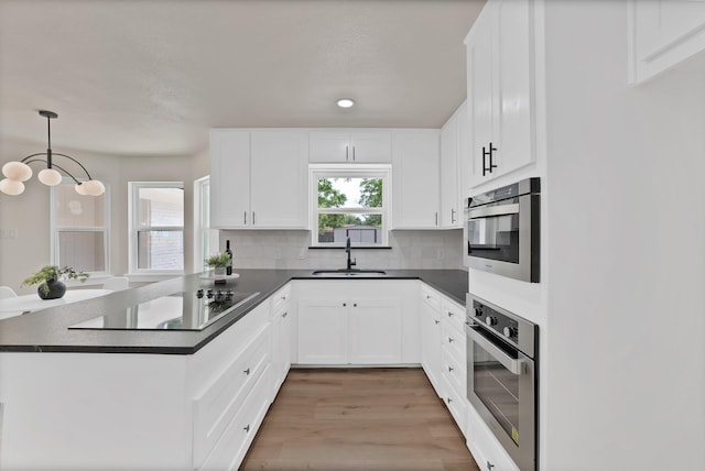 1146 Norwood Dr, Hurst, TX 76053 - kitchen with stainless steel oven, black electric stovetop, a sink, a peninsula, and dark countertops