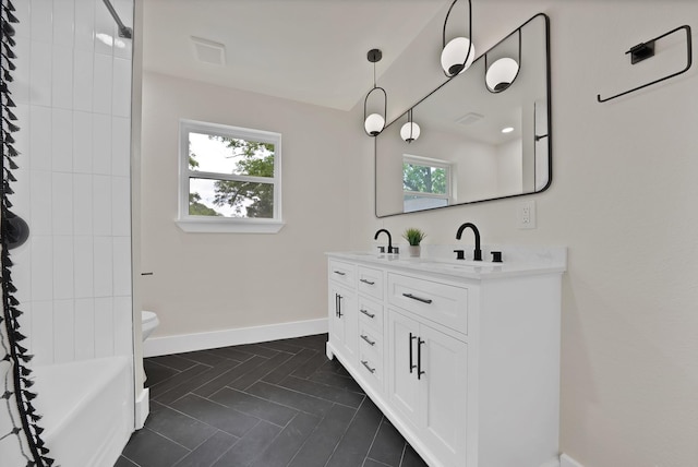 1146 Norwood Dr, Hurst, TX 76053 - bathroom featuring double vanity, toilet, and baseboards