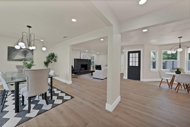 1146 Norwood Dr, Hurst, TX 76053 - dining area with a chandelier, light wood-style floors, baseboards, a fireplace, and recessed lighting