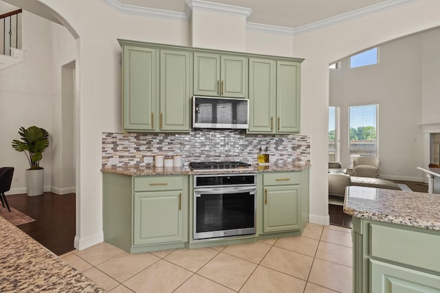 417 Burberry, Grand Prairie, TX 75052 - kitchen with green cabinetry, appliances with stainless steel finishes, arched walkways, tasteful backsplash, and crown molding