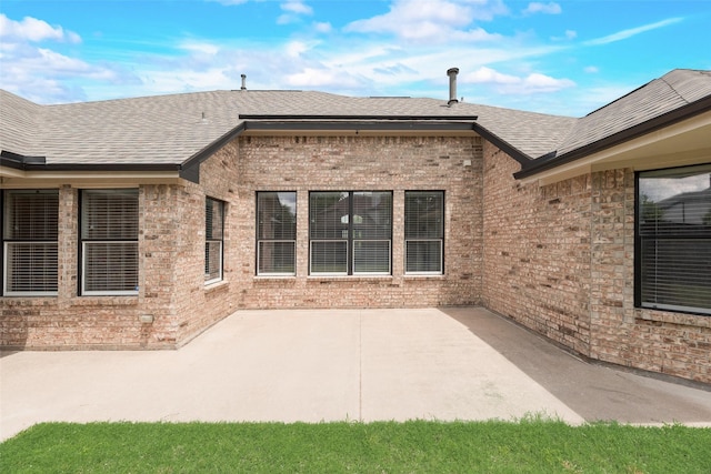 1527 Pleasant Run, Allen, TX 75002 - back of property featuring brick siding, roof with shingles, and a patio area