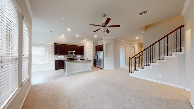 304 Eden Dr, Fate, TX 75189 - unfurnished living room featuring light carpet, ceiling fan, arched walkways, ornamental molding, and baseboards