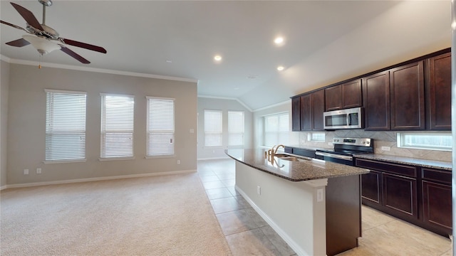 304 Eden Dr, Fate, TX 75189 - kitchen featuring stainless steel appliances, ornamental molding, a ceiling fan, dark stone counters, and an island with sink