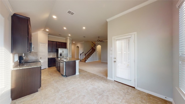 304 Eden Dr, Fate, TX 75189 - kitchen with stainless steel appliances, arched walkways, ornamental molding, ceiling fan, and light tile patterned flooring