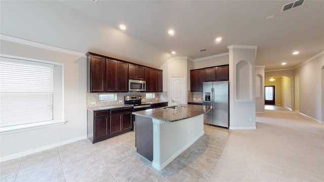 304 Eden Dr, Fate, TX 75189 - kitchen featuring stainless steel appliances, a sink, arched walkways, crown molding, and backsplash