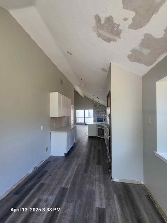 202 Sunset Dr, Glenn Heights, TX 75154 - kitchen featuring lofted ceiling, white cabinetry, dark wood-style floors, baseboards, and light countertops
