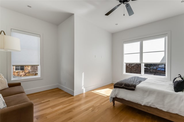 bedroom featuring light wood finished floors, baseboards, and ceiling fan