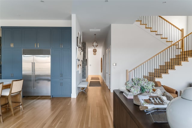entryway with light wood-style floors, stairs, and baseboards