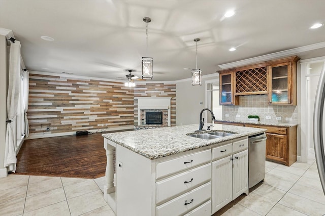 1309 Constitution Dr, Mckinney, TX 75071 - kitchen with a sink, dishwasher, a glass covered fireplace, a ceiling fan, and brown cabinets