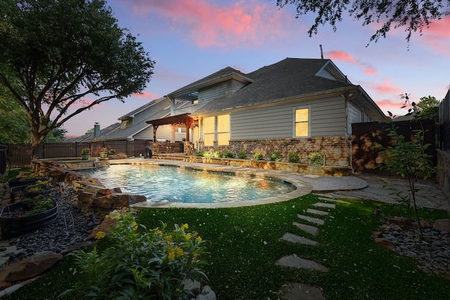 1309 Constitution Dr, Mckinney, TX 75071 - back of house at dusk featuring brick siding and a pool with connected hot tub